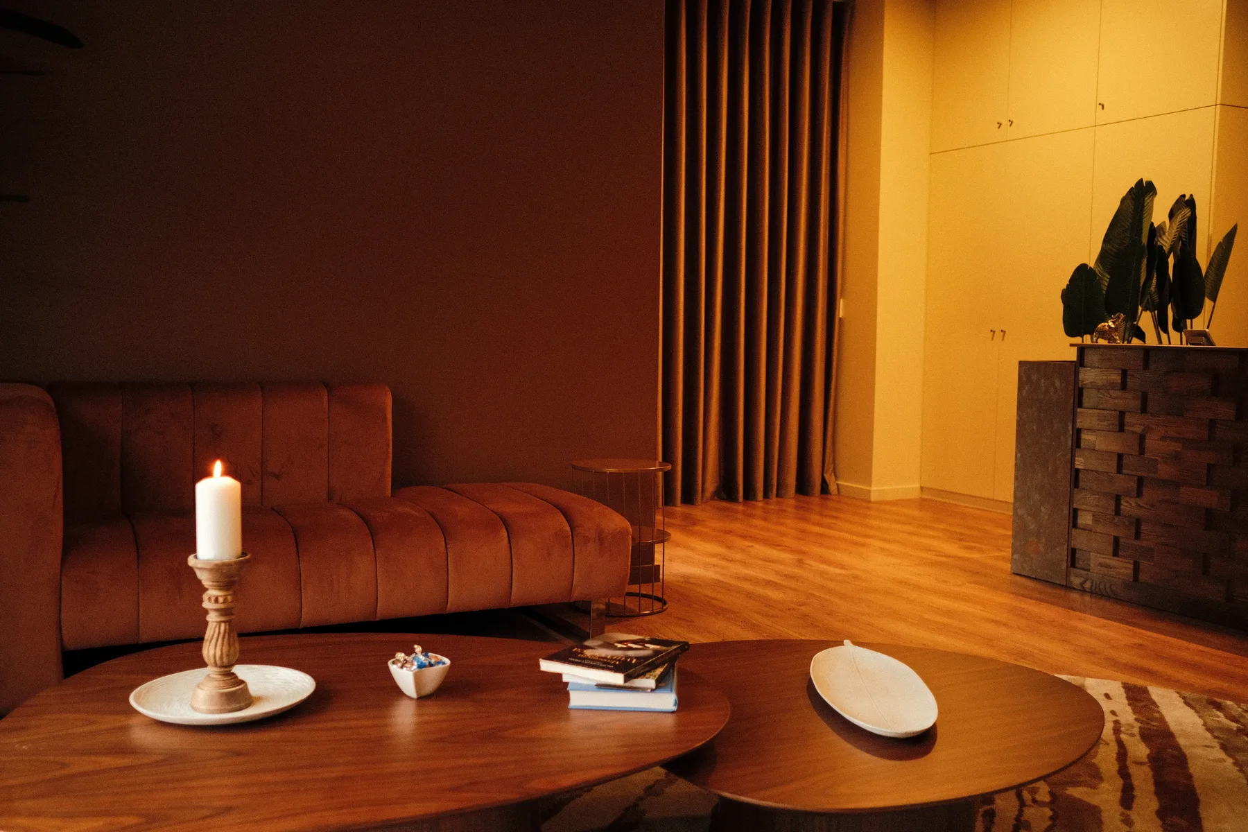 Sala de descanso Manu Hari com sofá, cortinas e luz suave